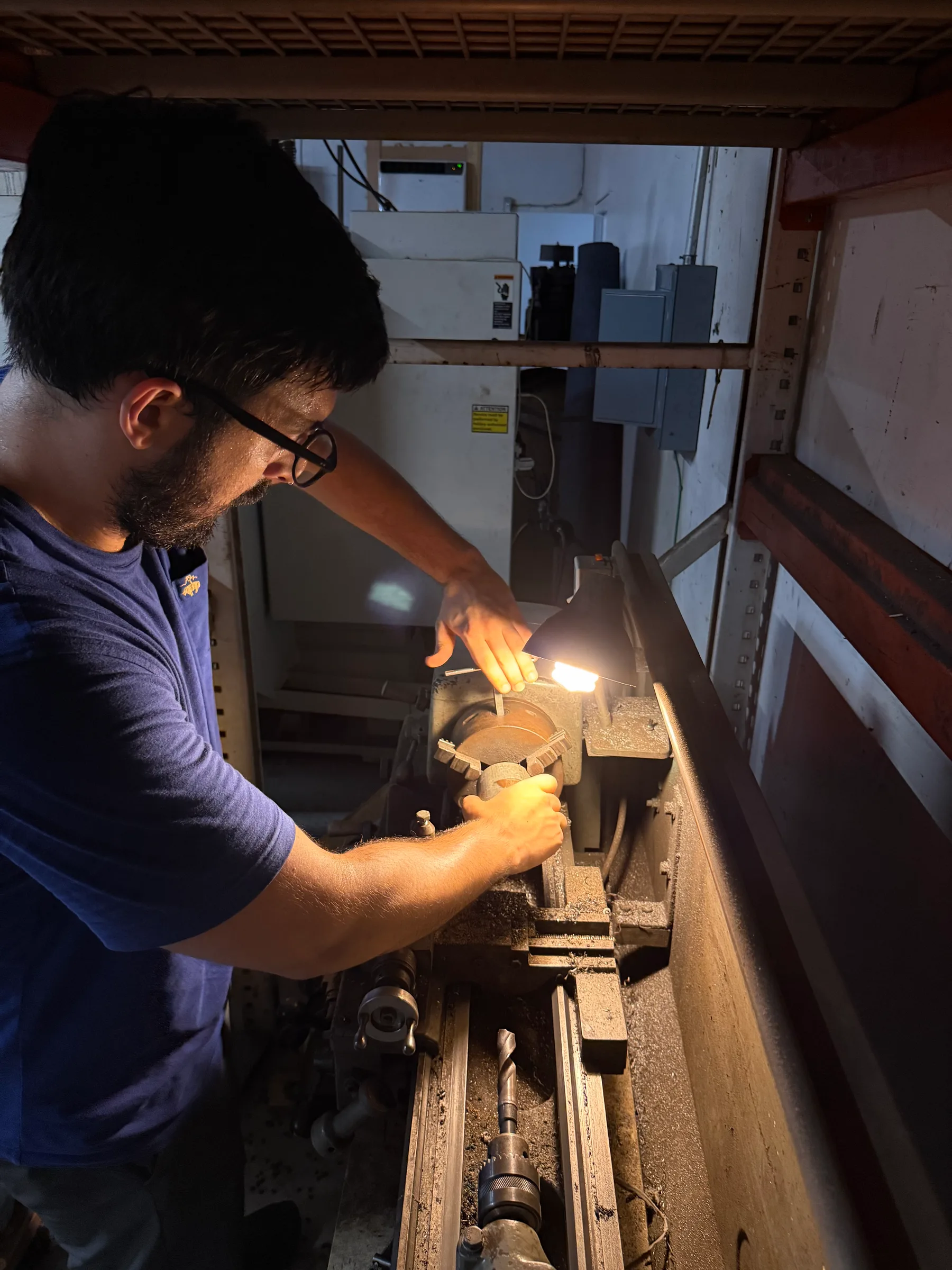 Nedim turning a part at the lathe in the Clearwater shop