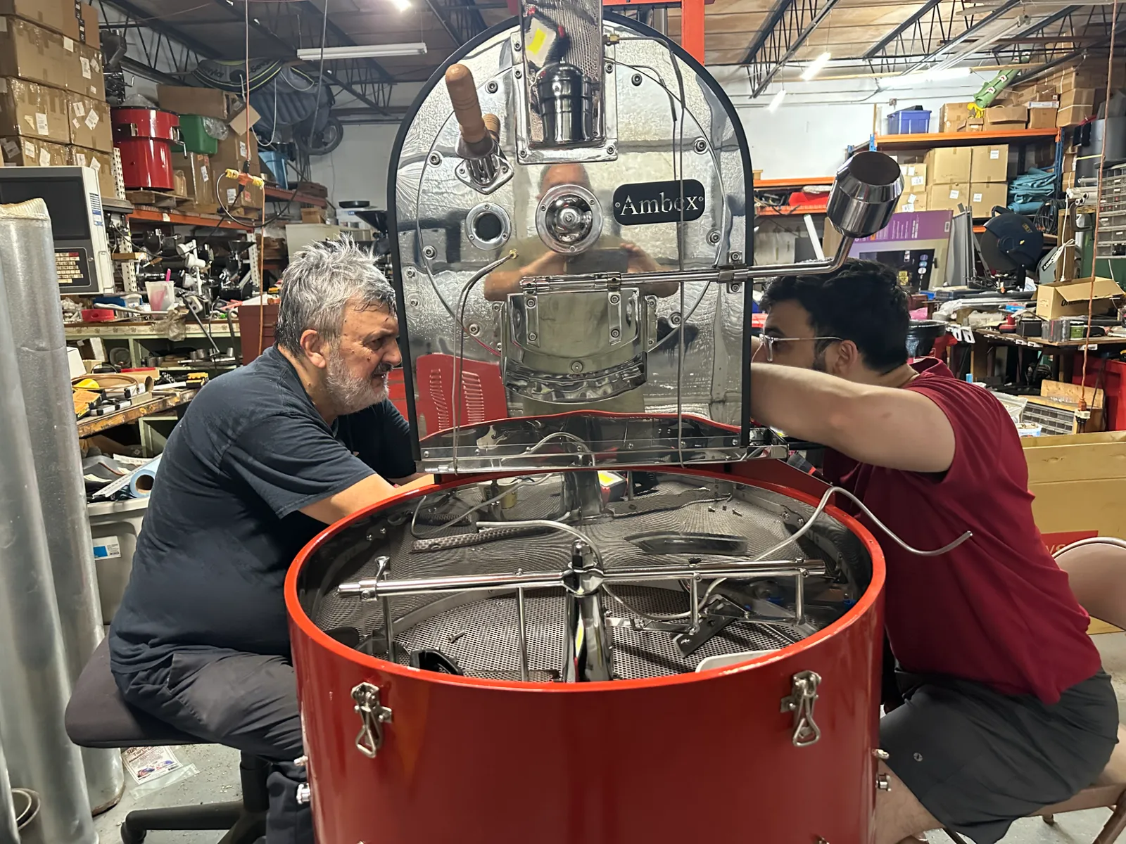 Amer and Nedim working together on an open roaster drum in the Clearwater shop