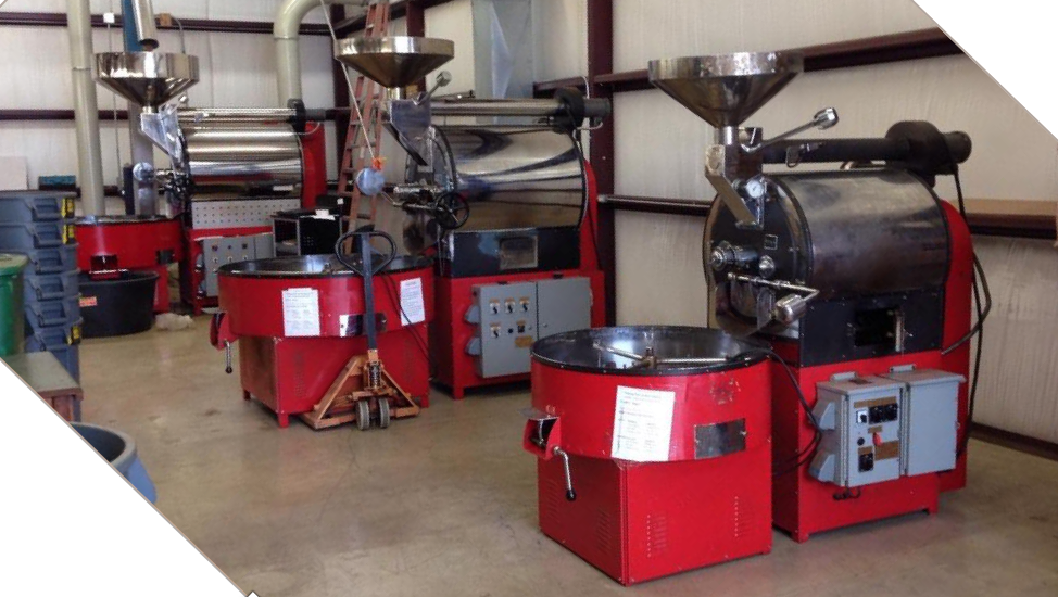 Three red Ambex roasters on a customer floor